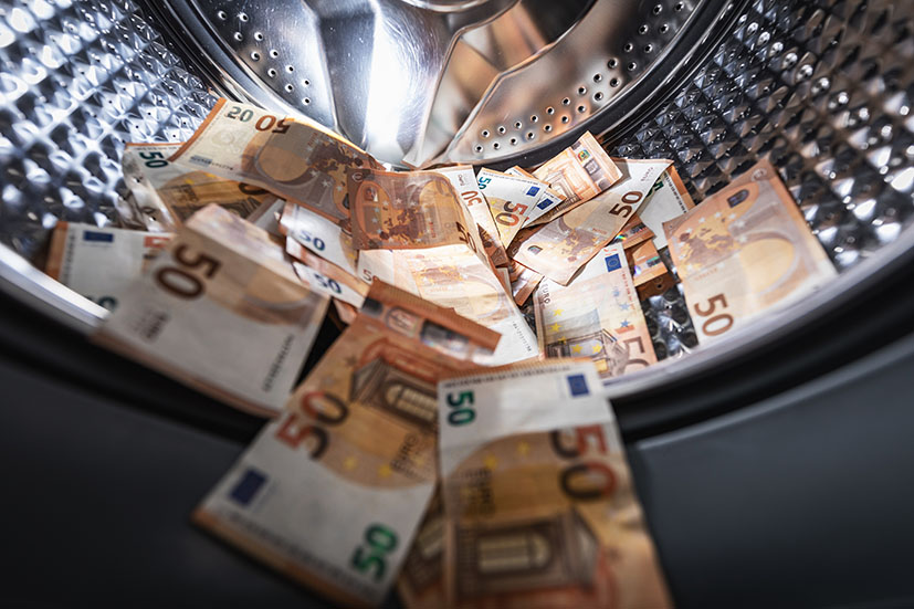 Image showing money inside a washing machine to depict money laundering 